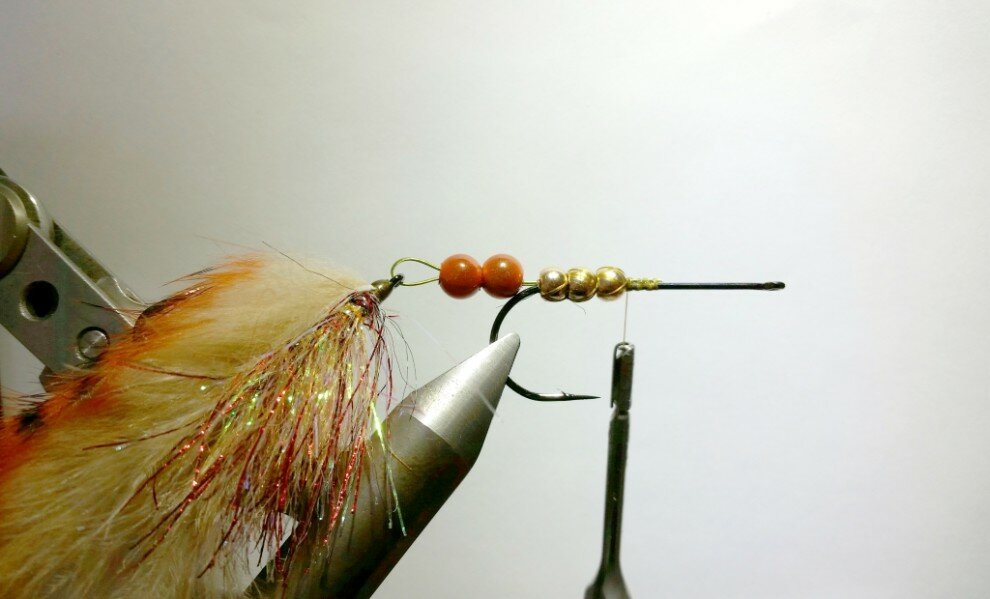 Add the rear hook and push the tungsten beads over the wire and stop just before the hook bend. Secure the beads with a couple of thread wraps.